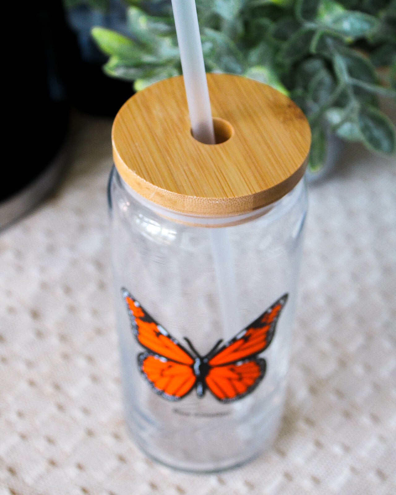 Clear tumbler with a wooden lid and straw, designed for iced coffee & iced drinks