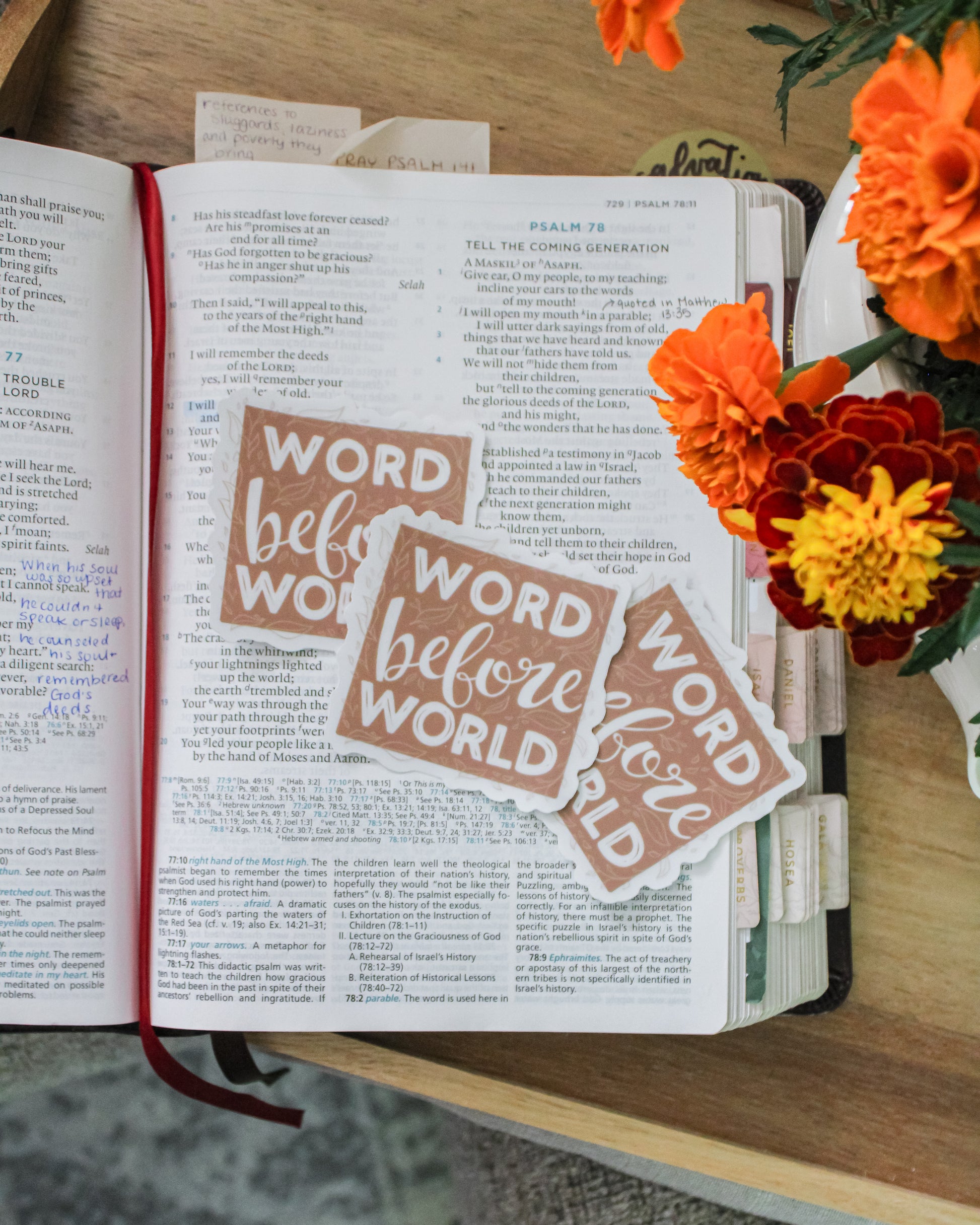 Open Bible with hand-lettered 'Word before World' stickers and flowers on a wooden tray